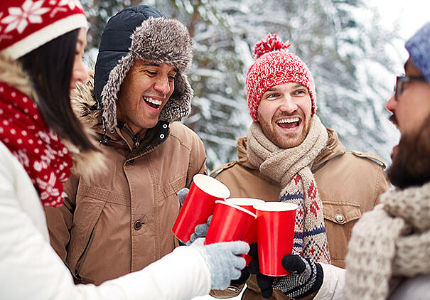 Personen in Winterkleidung trinken draussen Weihnachtsgetränke gemacht nach den Rezepten von SweetFamily