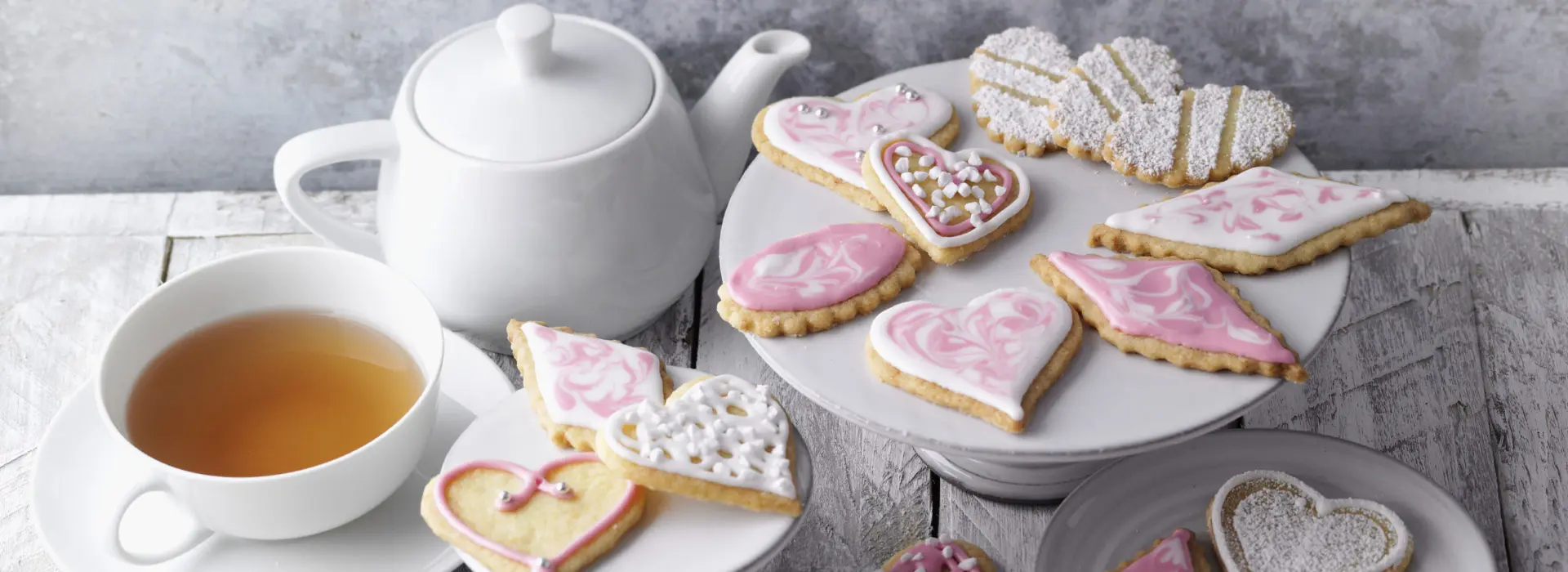 Butterplätzchen schön präsentiert neben einer Tasse Tee und einer Teekanne