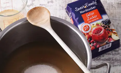 5. Den kalten Fruchtsaft … In den Kochtopf wurde gelierzucker gegeben. Daneben liegt die Verpackung: Gelierzucker von Sweetfamily