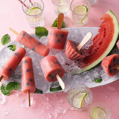 Eis aus Wassermelone selber gemacht in verschiedenen Formen liegt auf einem Teller voller Eiswürfel.