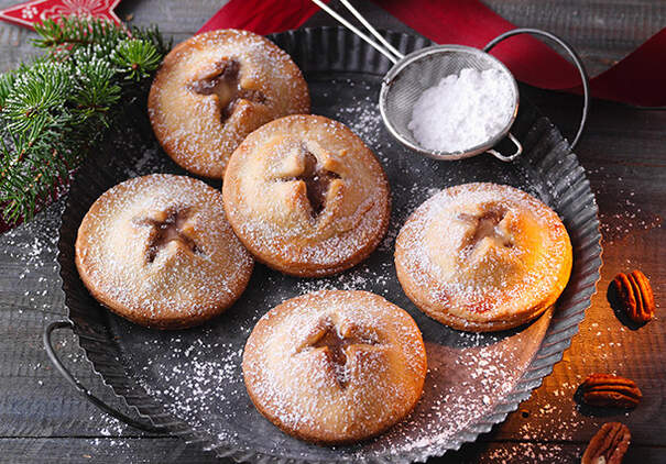 Kleine Hand Pies mit sternförmigen Teigdeckeln sind auf einem Backblech angeric