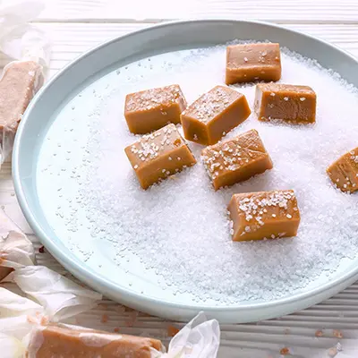 Sahnekaramell-Konfekt auf einen Teller mit Salz und Zucker verziert. 