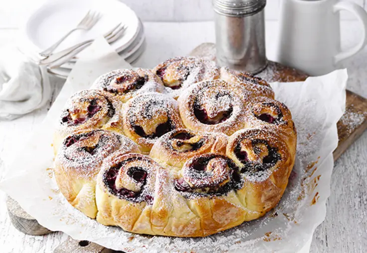 Hefeschnecken mit saftiger Mohnfüllung, mit Kirschen belegt und nach dem Backen mit Puderzucker bestäubt