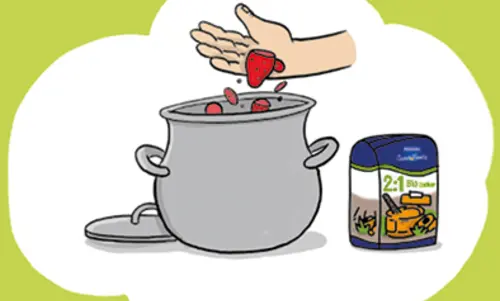 In einem großen Kochtopf werden Stückchen Erdbeeren geworfen. Daneben eine Packung Zucker von Sweetfamily.