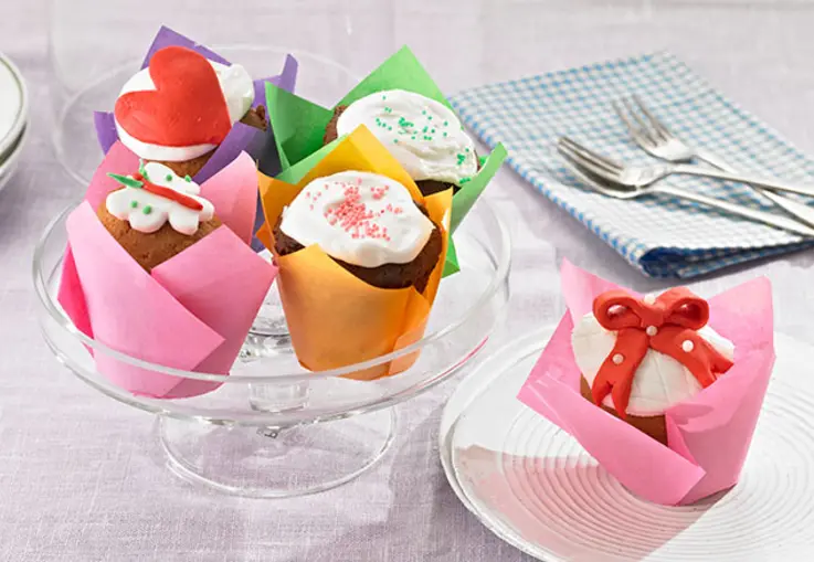 Helle und dunkle Cupcakes mit österlichen Motiven auf einer Etagere angerichtet.