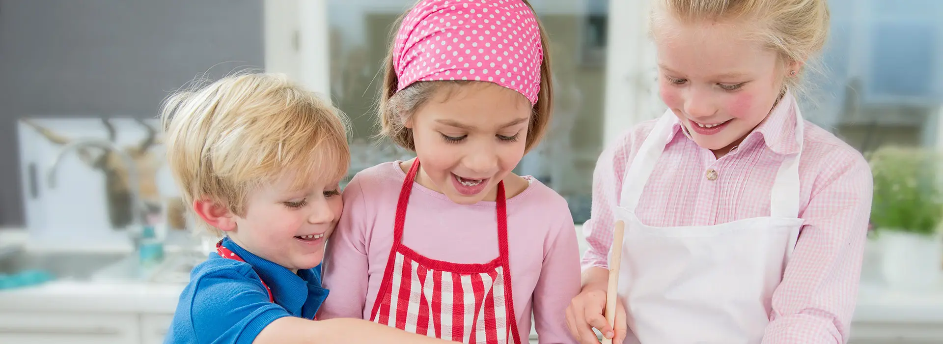 Drei Kinder haben Spaß beim backen.
