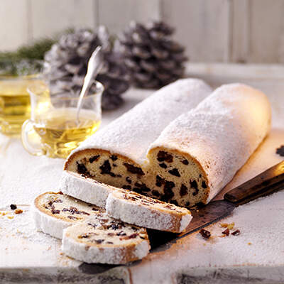 Dick mit Puderzucker bestäubter Christstollen mit Trockenfrüchten und Mandeln