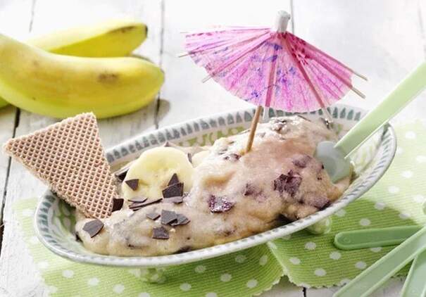 Eine Portion Vanilleeis mit Früchten und Soße wird als Dessert dekoriert.