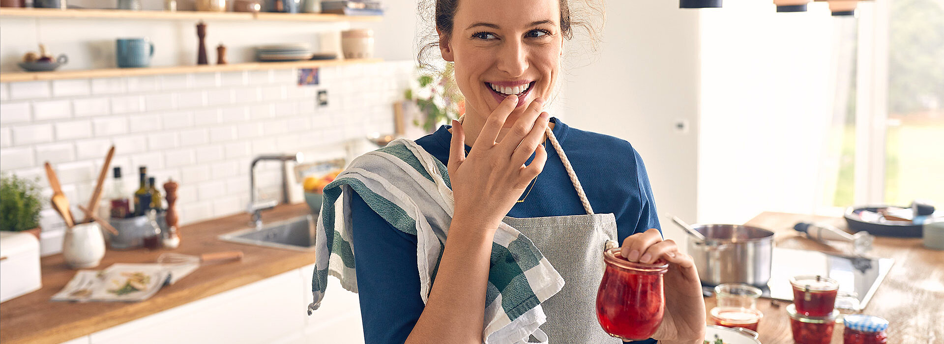 Frau zeigt ihre selbst gemachte Marmelade, gemacht nach einem Rezept von SweetFamily Marmelade selber machen Rezepte