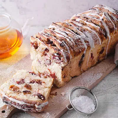 Pflaumenzupfbrot mit Puderzucker und einer Kanne Tee