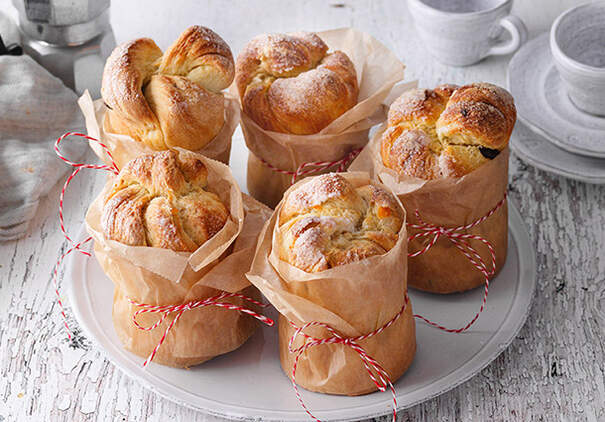 Kleine Panettone oder Hefebrote sind in Pergament eingewickelt und mit Schnur gebunden.