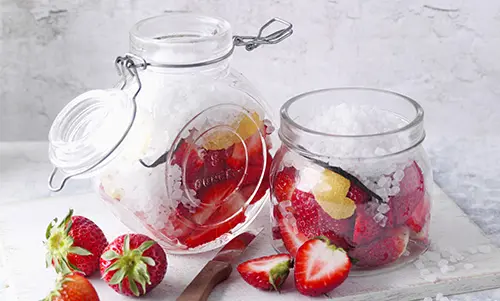 Erdbeeren in einer Dose mit Einmachzucker vermischt.