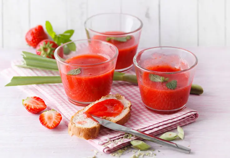 Kleine Gläschen sind gefüllt mit rotem Fruchtaufstrich