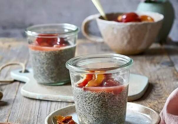 Zwei kleine Weckgläser sind bis zum Rand mit grauem Chia‑Pudding gefüllt und werden von einer Schicht oranger Fruchtkompott bedeckt.