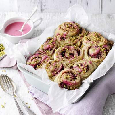 Ein Metallbehälter mit selbstgemachten veganen Müsliriegeln steht auf einer rot‑weißen Decke.