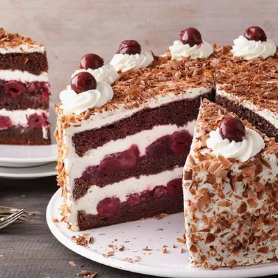 Schwarzwälder-Kirsch Torte bei der 2 große Stücken raus geschnitten sind.