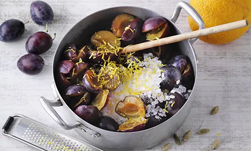 Schritt 1 Frische Pflaumen mit Gewürzen und Einmachzucker in einem Kochtopf.
