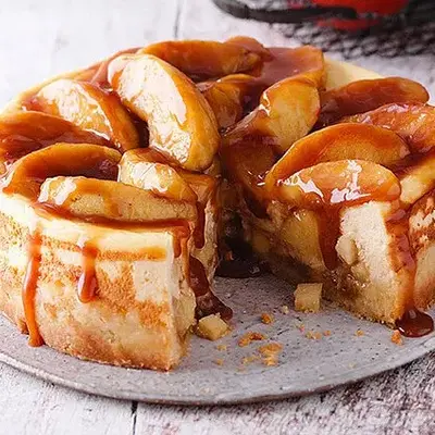 Karamell‑Apfelkuchen mit Nusskruste auf einer Platte.
