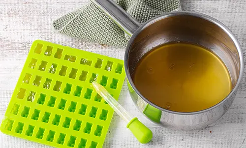 Die Flüssigkeit wird aus dem Topf mit einer Pipette in die Förmchen gegeben.