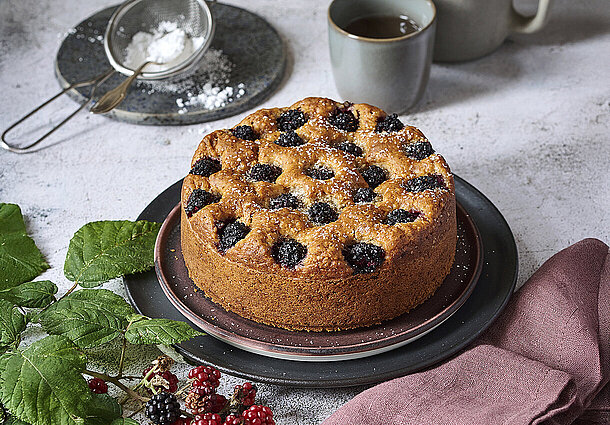 Veganer Kuchen in klassischer runder Form mit Mandeln und Brombeeren gebacken