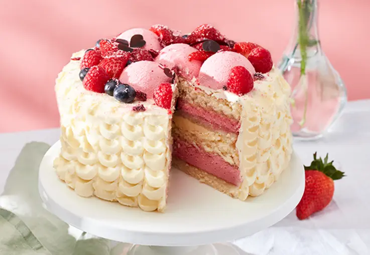 Torte mit heller Buttercreme und frischen Himbeeren, dekorativ auf der Oberfläche verteilt.
