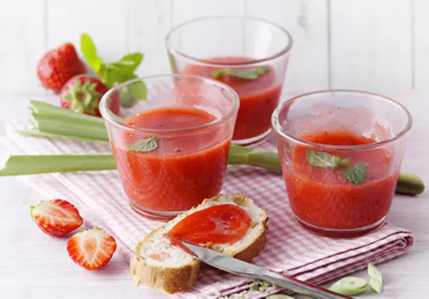 Drei kleine Gläser mit zartrosa Erdbeer‑Zitronengras‑Aufstrich, dazu frische Beeren, Brotstückchen und Zitronengrasstängel