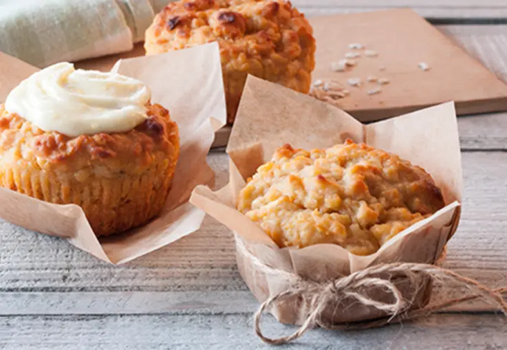 Muffins mit geriebenen Karotten und Äpfeln, aus Haferflocken und Joghurt, mit cremigem Frischkäse-Frosting und Zuckerperlen dekoriert