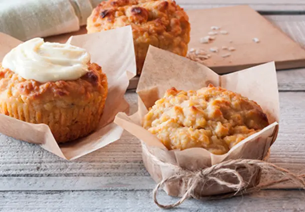 Muffins mit geriebenen Karotten und Äpfeln, aus Haferflocken und Joghurt, mit cremigem Frischkäse-Frosting und Zuckerperlen dekoriert